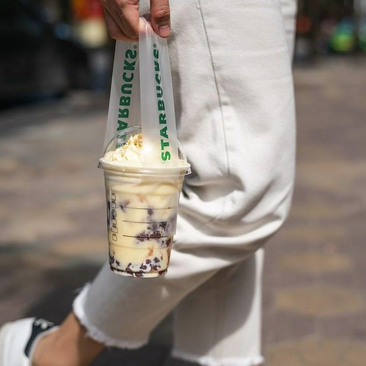 Woman holding Starbucks coffee